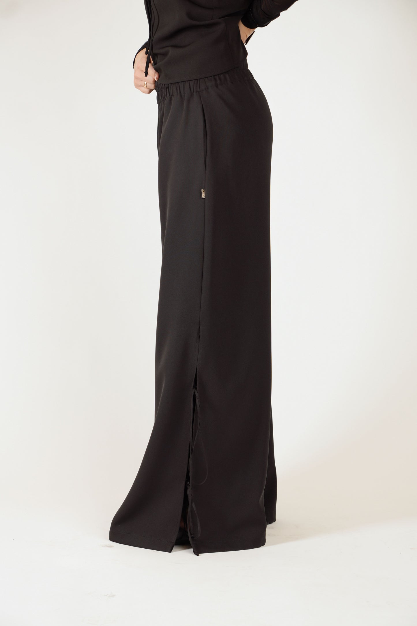 Melnas platas bikses ar šķēlumiem, gumijas jostu un sānu kabatām