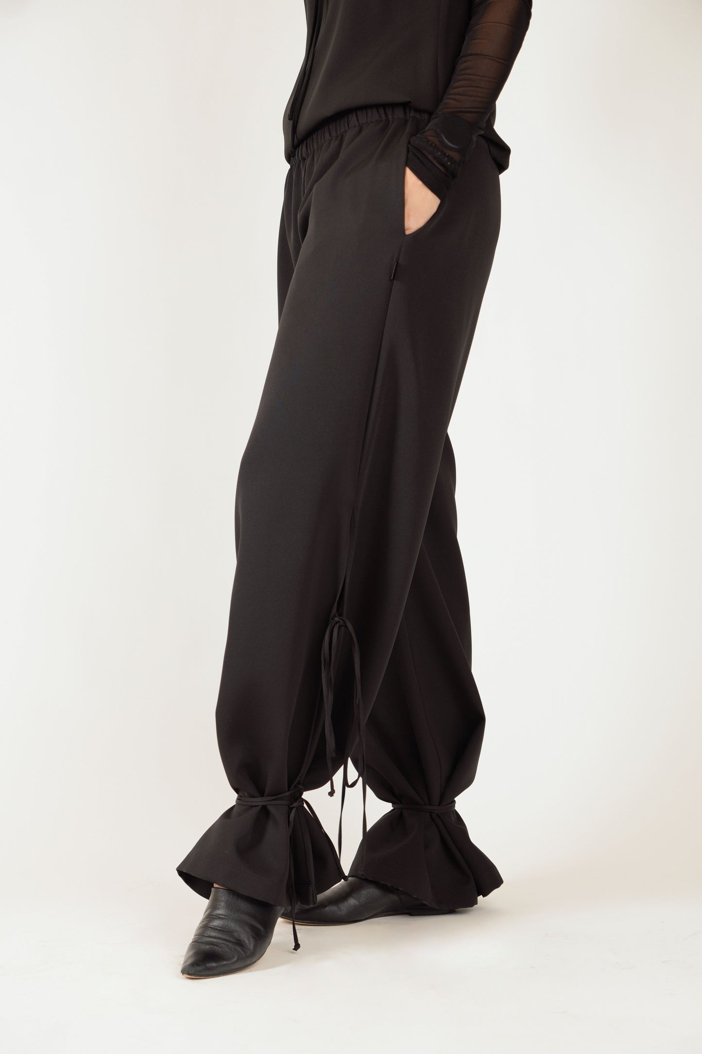 Melnas platas bikses ar šķēlumiem, gumijas jostu un sānu kabatām