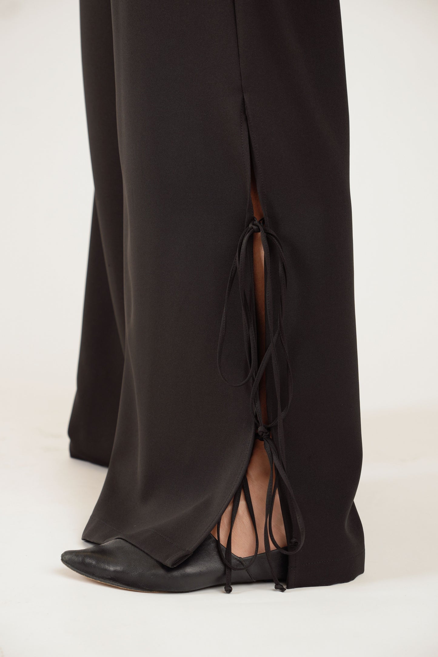 Melnas platas bikses ar šķēlumiem, gumijas jostu un sānu kabatām