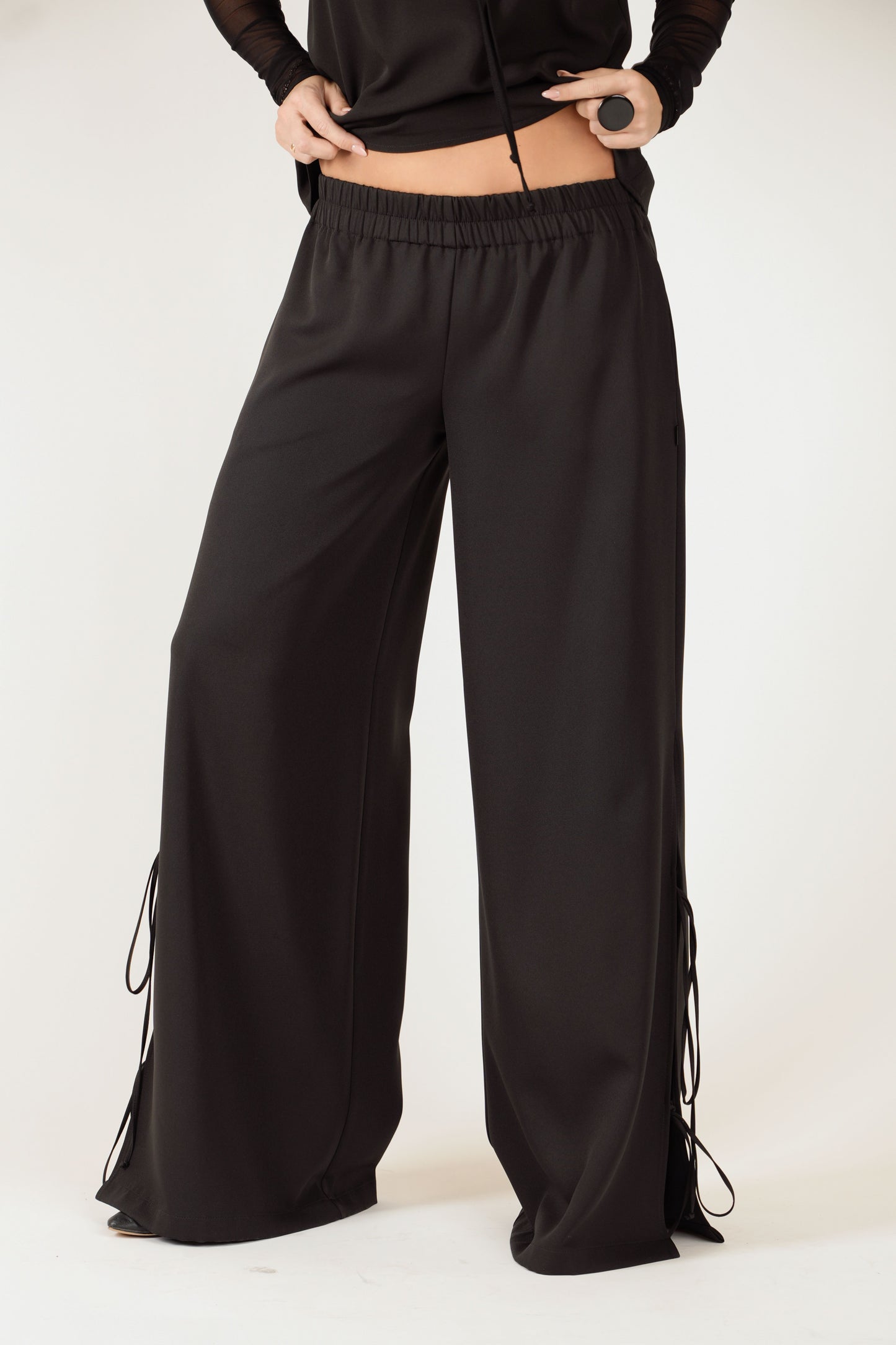 Melnas platas bikses ar šķēlumiem, gumijas jostu un sānu kabatām