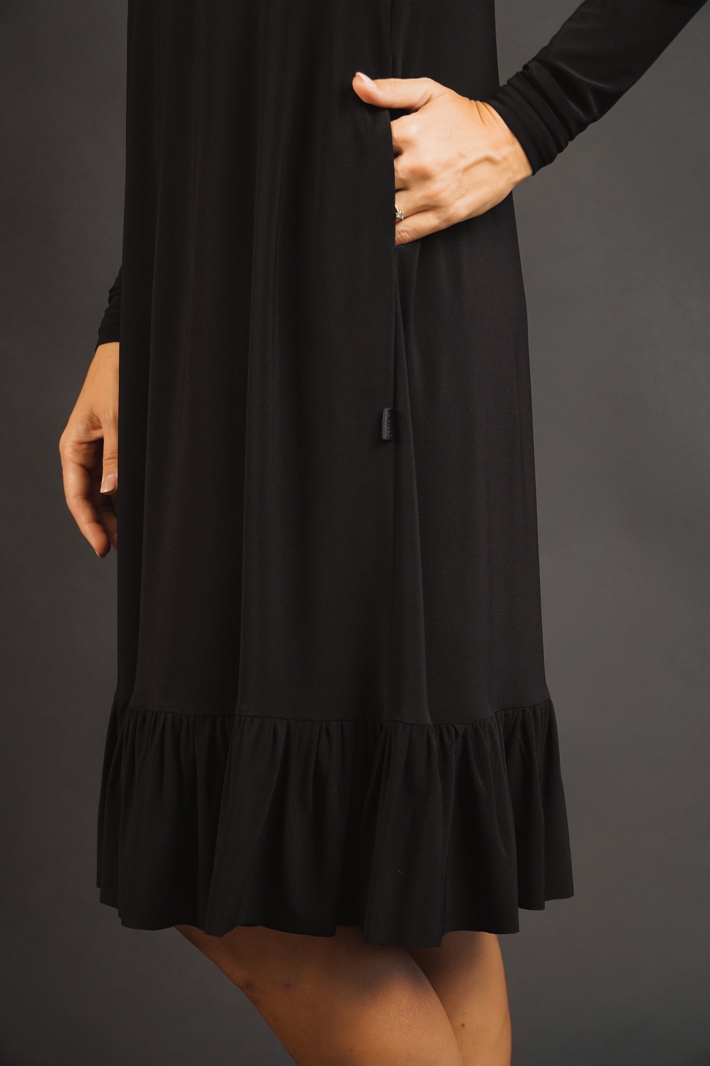 Melna kleita ar volānu no elastīga auduma