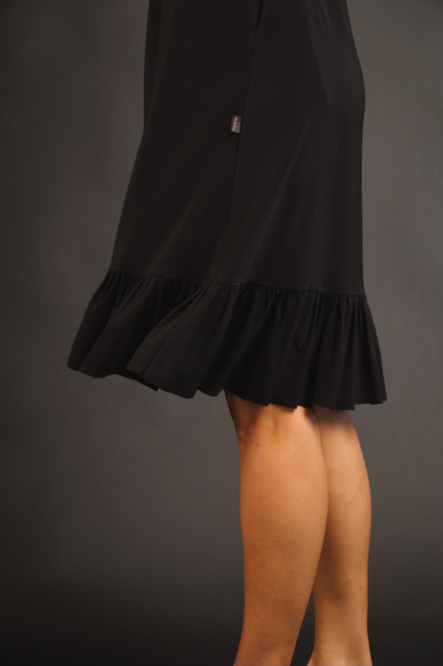 Melna kleita ar volānu no elastīga auduma