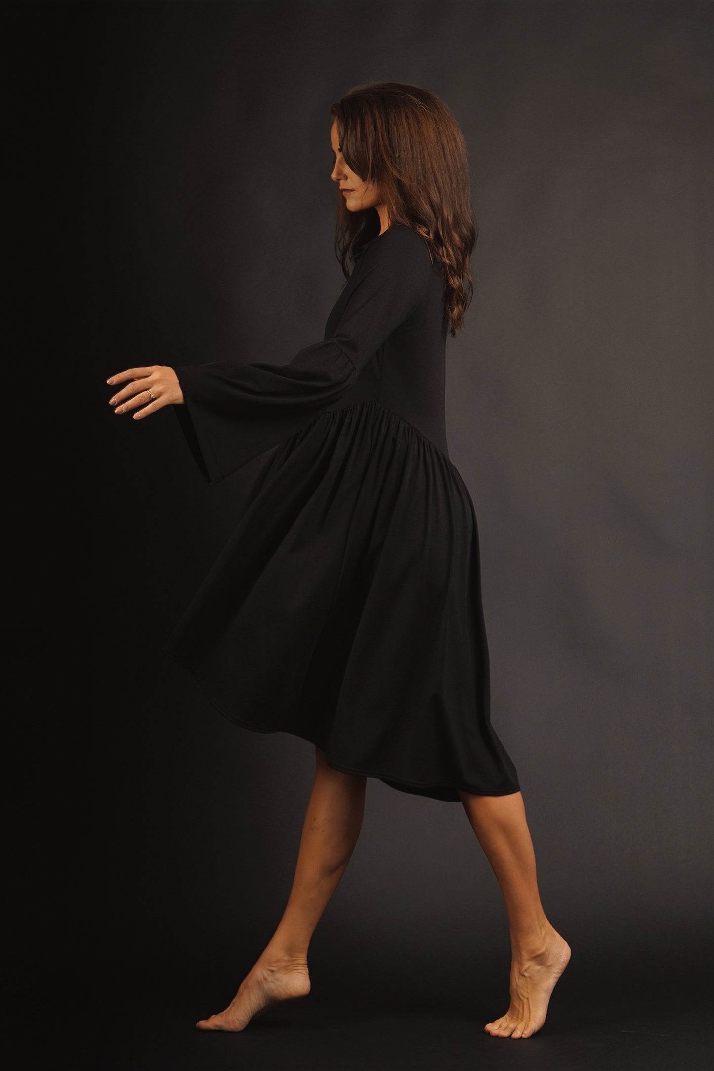 Kleita ar slīpu volānu un paplatinātām piedurknēm