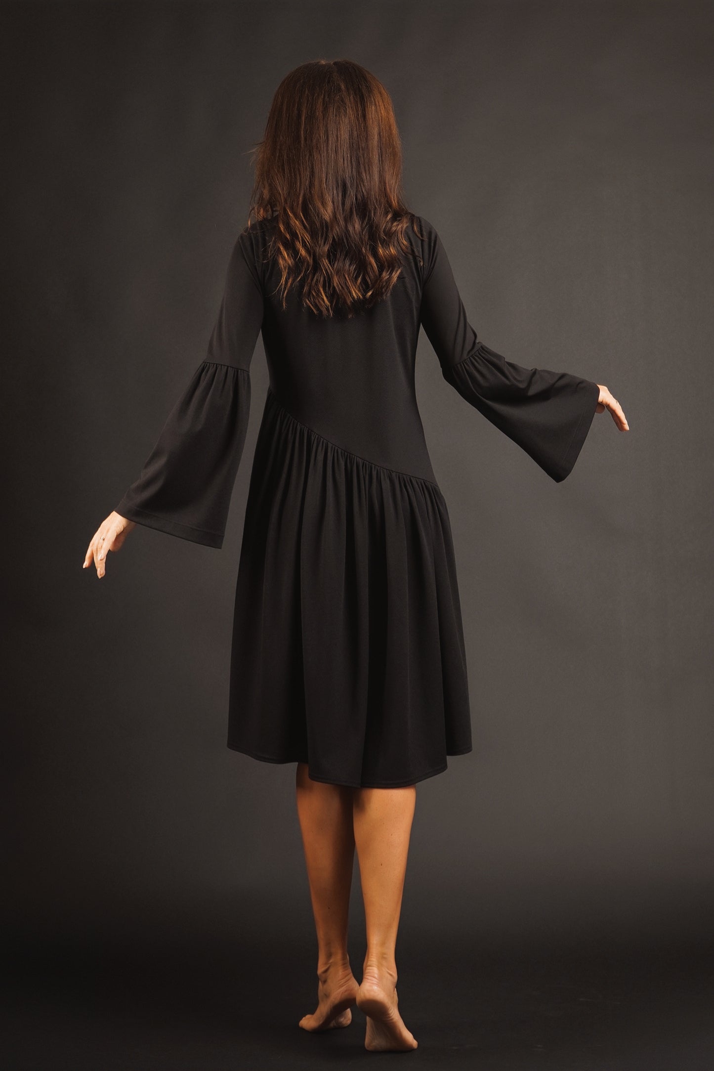 Kleita ar slīpu volānu un paplatinātām piedurknēm