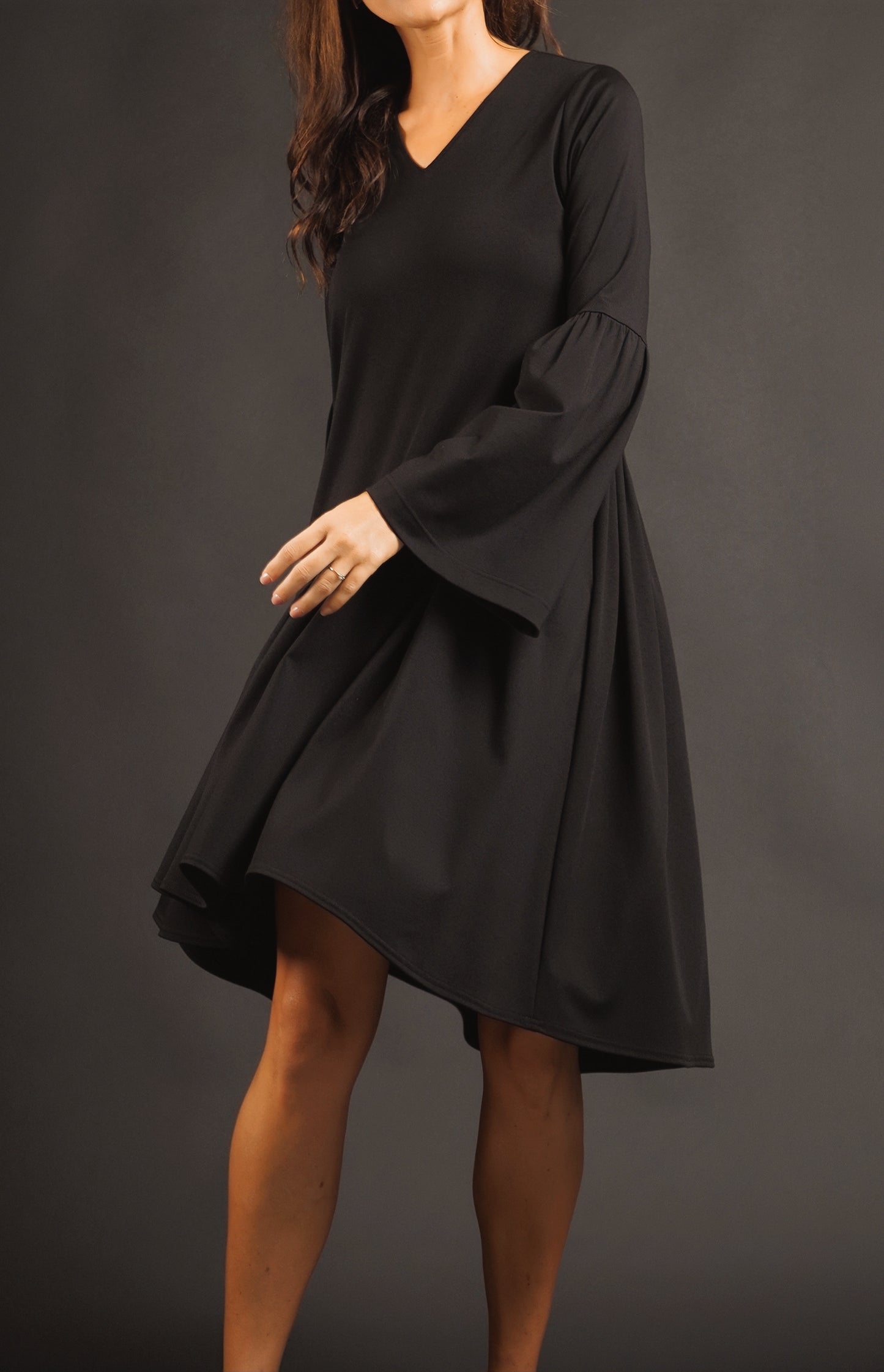 Kleita ar slīpu volānu un paplatinātām piedurknēm