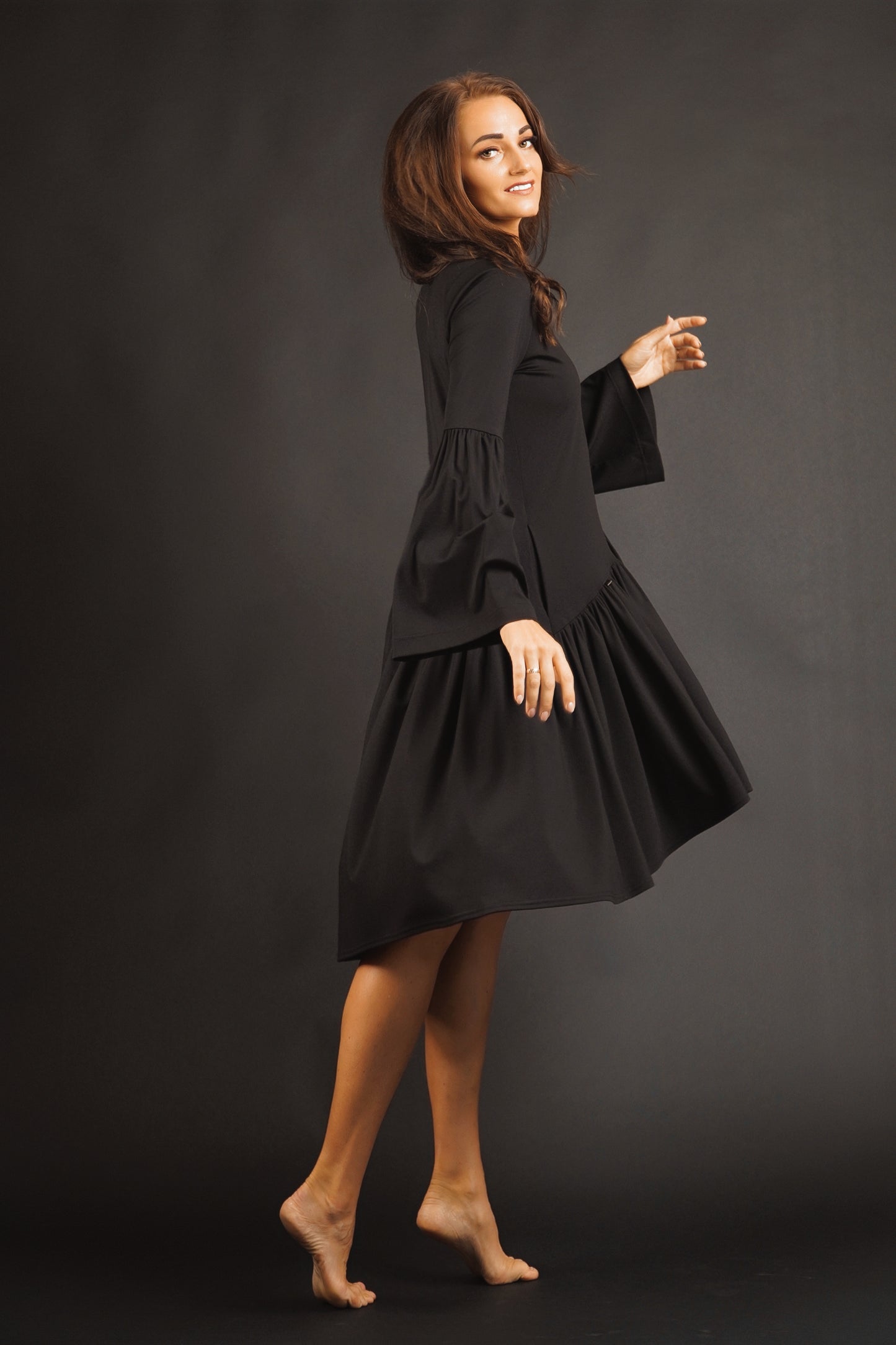 Kleita ar slīpu volānu un paplatinātām piedurknēm