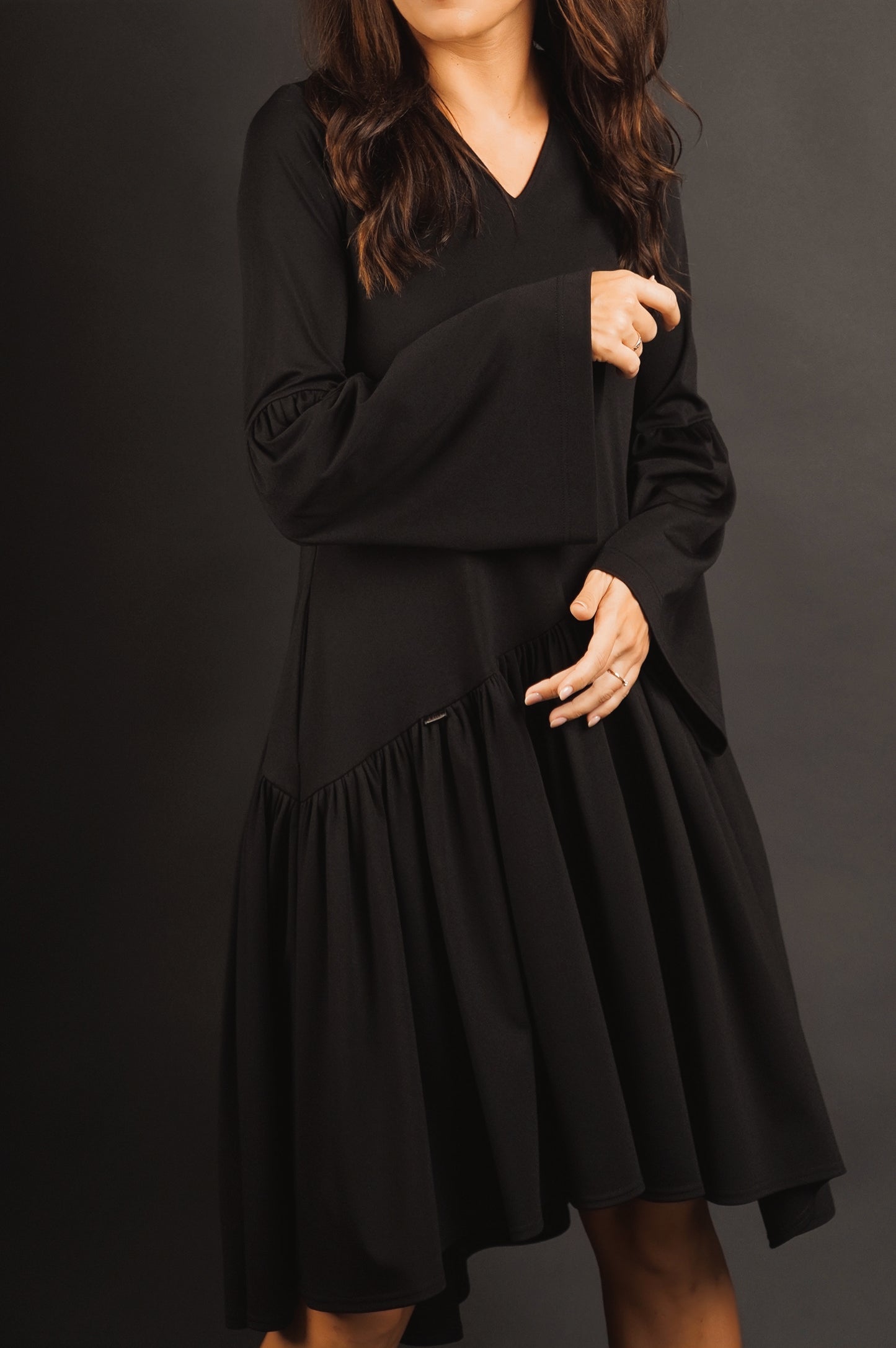 Kleita ar slīpu volānu un paplatinātām piedurknēm