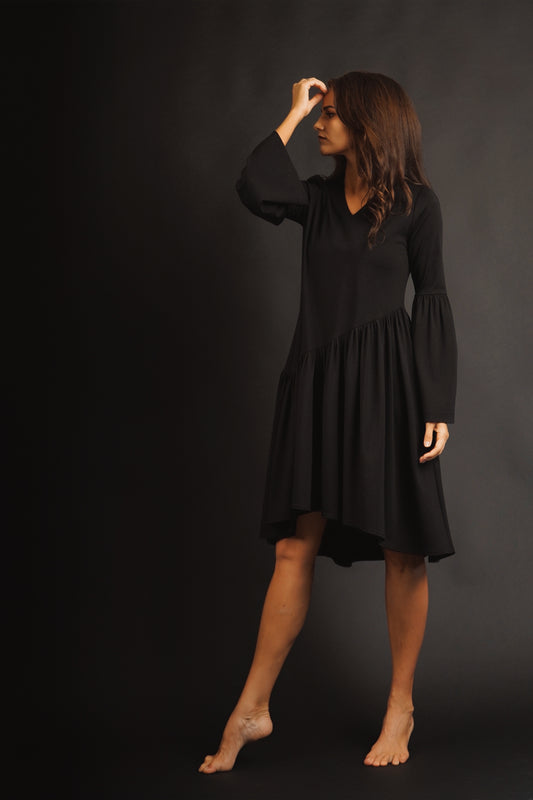 Black dress with a slanted flounce and flared sleeves